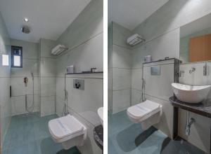 ein Badezimmer mit zwei Toiletten und einem Waschbecken in der Unterkunft Hotel 7 skye in Surat