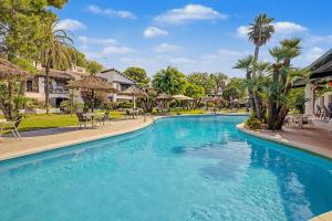 a swimming pool in a resort with tables and chairs at Casa Del Sol in Calafell