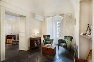 a living room with two chairs and a table at P43 Sicilian Suites in Ragusa