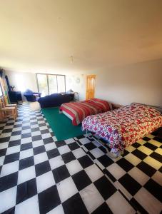 a bedroom with two beds and a checkered floor at Lodge & Camping Suma Samawi in Copacabana