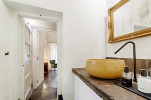 a bathroom with a yellow bowl on a counter at P43 Sicilian Suites in Ragusa