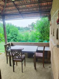a table and chairs on a patio with a window at Shivakashi Homestay in Maheshwar