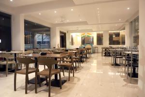 a restaurant with tables and chairs in a room at Hotel Ellora Pride in Ellora