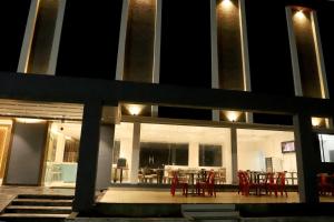 a building with red chairs and a table in it at Hotel Ellora Pride in Ellora