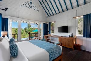 a bedroom with a bed and a desk and a television at Emana Aruna in Toyapakeh