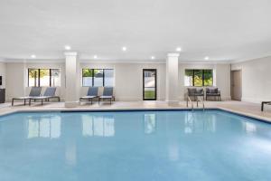 a large pool in a hotel with chairs and tables at Hampton Inn Portage in Portage