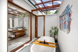 a bathroom with a toilet and a sink and a mirror at Emana Aruna in Toyapakeh +17 photos