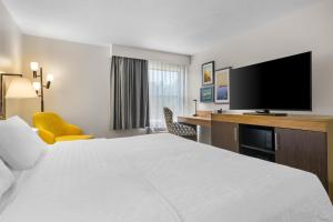 a hotel room with a bed and a flat screen tv at Hampton Inn Portage in Portage