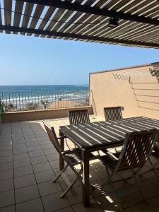 a table and chairs on a patio with the beach at Casa Médano 12 in El Médano