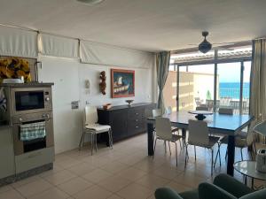 a kitchen and dining room with a table and chairs at Casa Médano 12 in El Médano