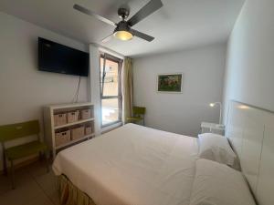 a bedroom with a white bed and a ceiling fan at Casa Médano 12 in El Médano