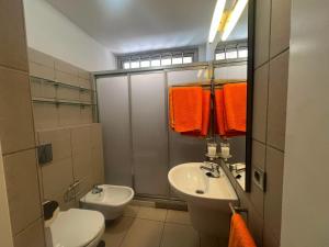 a bathroom with a white toilet and a sink at Casa Médano 12 in El Médano