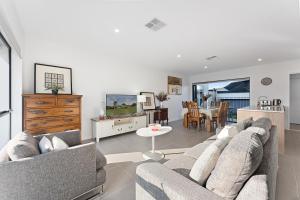 a living room with two couches and a dining room at Homenest in Gledswood Hills