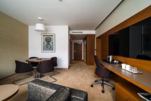 ein Hotelzimmer mit Schreibtisch, Stühlen und Tisch in der Unterkunft Mikado Hotel in Nitra + 101 Fotos