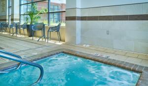 a swimming pool in a building with chairs and a table at Hampton Inn & Suites Salinas in Salinas