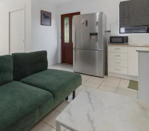 a living room with a green couch and a refrigerator at Elegant & Cozy Private Studio in Wellington Point