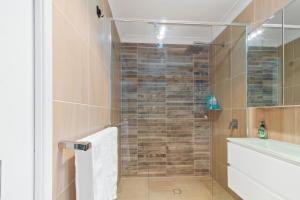 a bathroom with a shower with a glass door at Elegant & Cozy Private Studio in Wellington Point