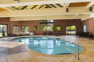a large pool in a building with chairs and tables at Doubletree by Hilton, Leominster in Leominster