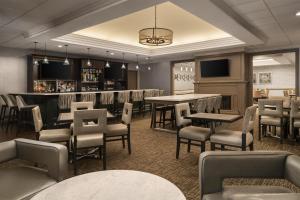 a restaurant with tables and chairs and a bar at Doubletree by Hilton, Leominster in Leominster
