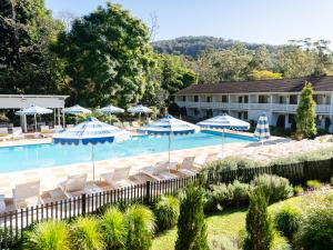 a large swimming pool with chairs and umbrellas at The Lodge Jamberoo in Jamberoo
