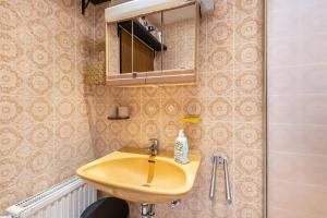 a bathroom with a yellow sink and a mirror at Ferienwohnung Bayerwald in Arrach +17 photos
