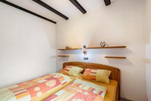 a bedroom with two beds and shelves on the wall at Ferienwohnung Bayerwald in Arrach