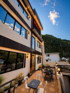 a patio with tables and chairs in front of a building at Jace's Travellers Inn El Nido near Corong Corong Beach in El Nido