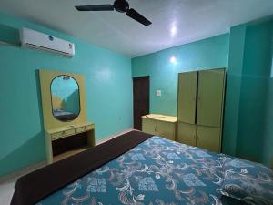 a bedroom with a bed with a mirror and a dresser at Dmello guesthouse in Palolem