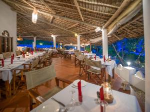 a dining room with white tables and chairs at Zoi Retreat Hotel Zanzibar in Matemwe