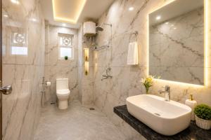 a bathroom with a sink and a toilet and a mirror at SG Royal Portico in Haridwār