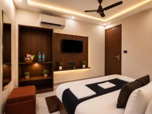 a bedroom with a bed and a flat screen tv at SG Royal Portico in Haridwār