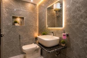 a bathroom with a sink and a toilet and a mirror at SG Royal Portico in Haridwār