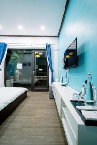 a bedroom with a bed and a sink and a tv at Coto Center Homestay in Đảo Cô Tô