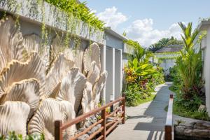 a walkway in front of a fence with plants at THE SAND Suites & Villas in Ngurah Rai International Airport