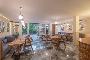 a restaurant with wooden tables and chairs and windows at THE SAND Suites & Villas in Ngurah Rai International Airport