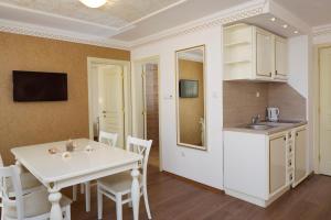 eine Küche und ein Esszimmer mit einem weißen Tisch und Stühlen in der Unterkunft Hotel Golden Ina in Sonnenstrand