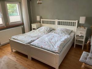 a bedroom with a white bed and two night stands at Zimmer Mühlenbach, ein Zimmer in FeWo mit 2 Zi in Schieder-Schwalenberg