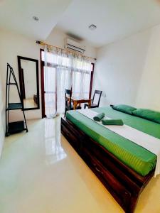 a bedroom with a large bed and a table at Footmark Surf Stay in Pottuvil