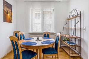 a dining room with a table and blue chairs at Untermühle Horchheim in Worms