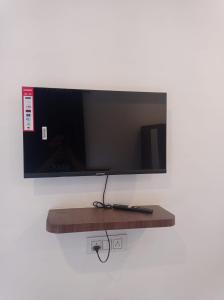 a flat screen tv hanging on a wall at Hotel rose palace in Dehradun