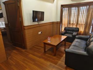 a living room with a couch and a table at Kohinoor Hotels in Erode