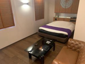 a small room with a bed and a couch at Rplus八千代 in Chiba