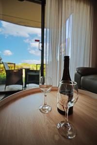 a bottle of wine and two glasses on a table at Apollo Bay Waterfront Motor Inn in Apollo Bay