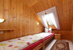a bedroom with a bed in a wooden room at Ferienhaus Richter in Drognitz
