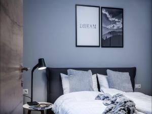 a bedroom with a bed with white sheets and blue pillows at Modern apartment in Schwaz in Schwaz