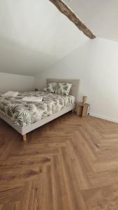 a bedroom with a bed and a wooden floor at Clos de la Vigne Saint Roch in Crêches-sur-Saône
