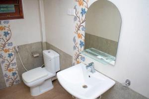 a bathroom with a sink and a toilet and a mirror at Kiula Resort in Hambantota