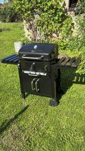a grill sitting in the grass next to a bench at Green House Giławy in Giławy +11 photos