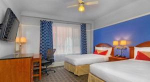 a hotel room with two beds and a desk at The Monarch Hotel in San Francisco