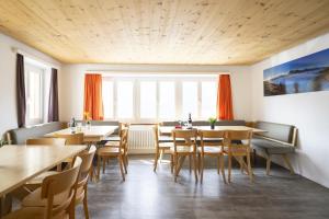 a dining room with wooden tables and chairs at Chasa Macun in Schleins